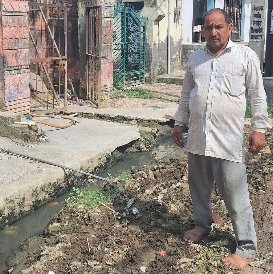 Satish Chand, a local resident shows the piped water connection sitting close to sewage / Credit: Rohini Krishnamurthy.